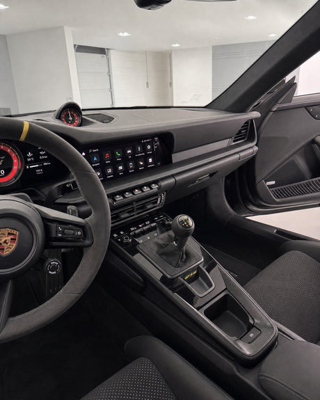 Seidenmatt gepflegtes Armaturenbrett im Innenraum eines weißen Porsche 911 GT3 RS, gleichmäßiges Mattfinish ohne Glanz.