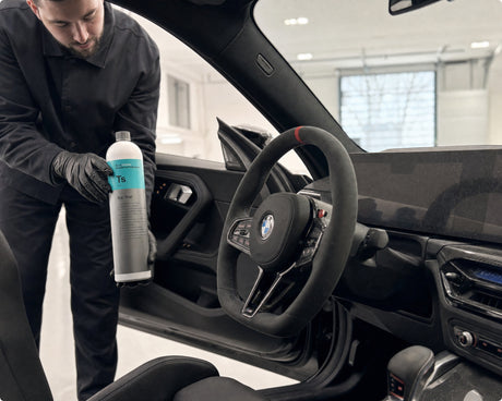 Detailing1 Koch-Chemie Top Star Ts — Daniel mit der Innenraum-Kunststoffpflege am offenen Cockpit eines schwarzen BMW M2