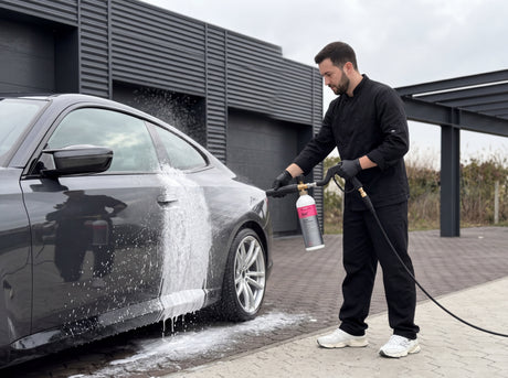 Daniel trägt Koch-Chemie Gentle Snow Foam mit der Schaumlanze auf die Karosserie eines dunklen Sportwagens mit silbernen Felgen auf — gezeigt im Artikel „Heute bedeckt, ab morgen Sonne. Dazwischen liegt dein Polier-Tag."