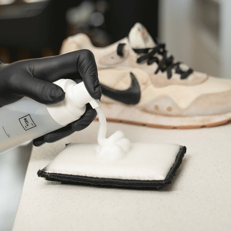 detailing1depot.comLOURLOCK Sneaker Cleaner — Reinigungsschaum auf dem Pad, dahinter der verschmutzte Sneaker